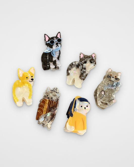 Cartoon cats and dogs acetate claw clips — all six designs on a light gray background
