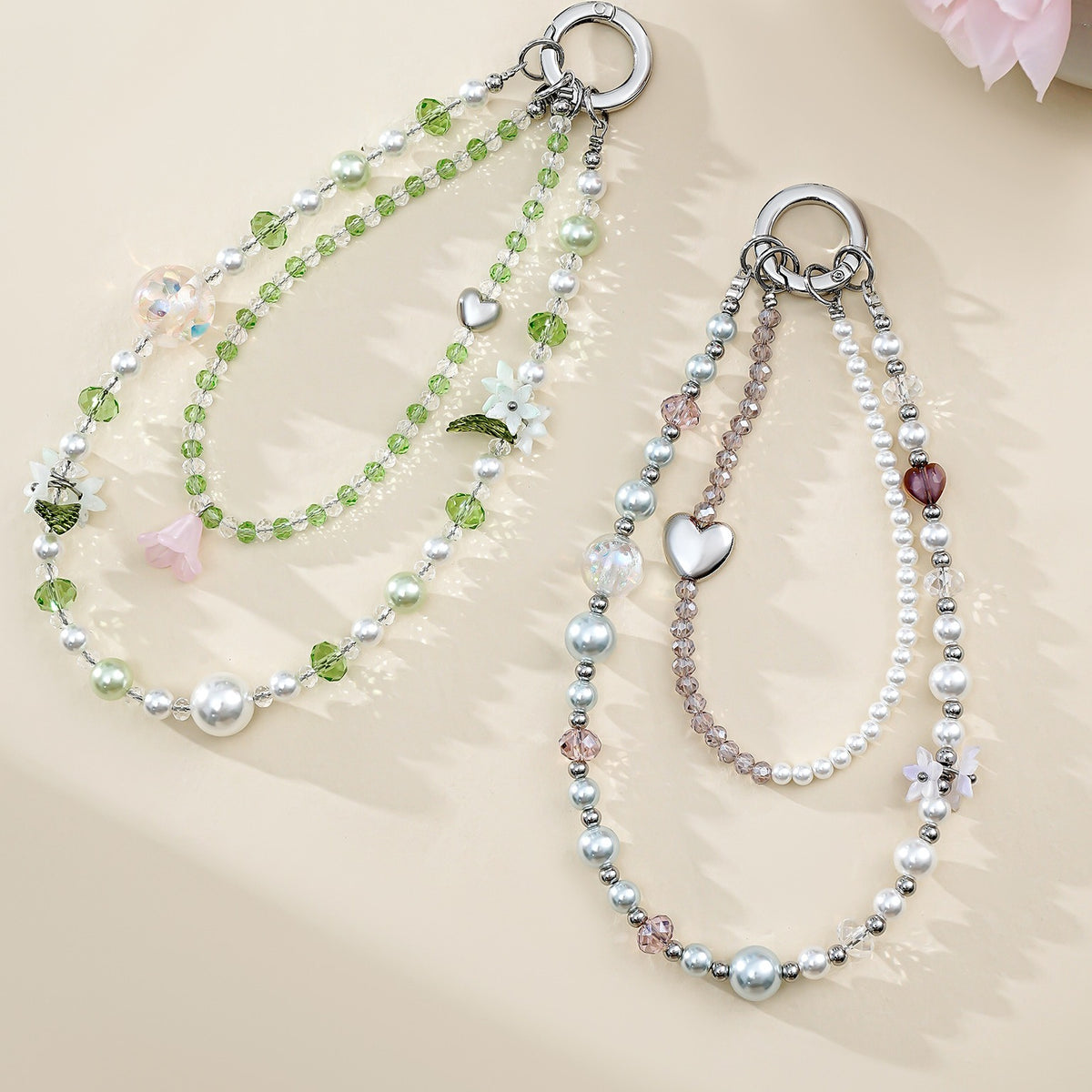 Two crystal bead phone wristlet chains laid flat