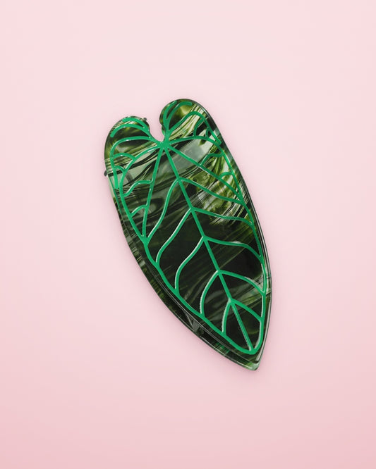 Emerald Alocasia leaf claw clip on a blush pink background
