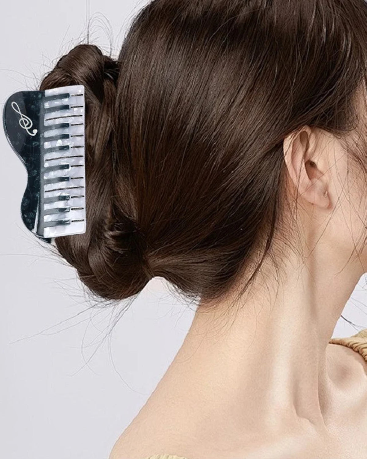 Midnight Keys piano claw clip worn in a low twisted bun
