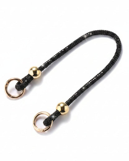 A clear mobile phone case with a luxury rhinestone lanyard attached to it, featuring a sparkling strap and rhinestone clasps.