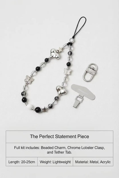 Beaded charm with chrome lobster clasp and tether tab on a white background