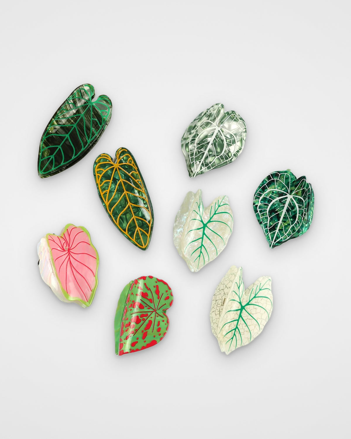 Tropical leaf claw clips — all eight leaf designs on a light gray background