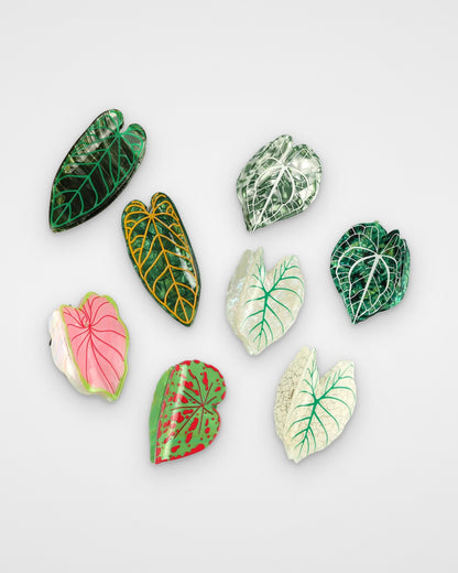 Tropical leaf claw clips — all eight leaf designs on a light gray background