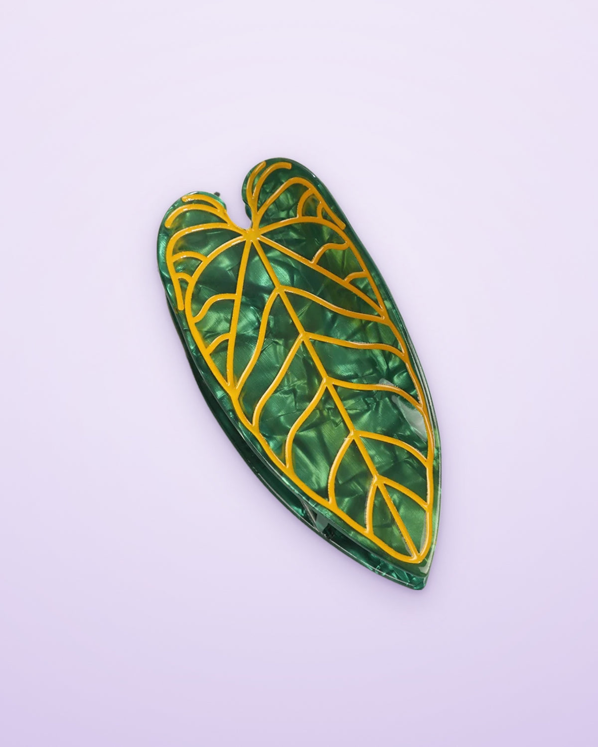 Golden Vein Alocasia leaf claw clip on a lavender background