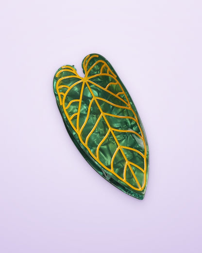 Golden Vein Alocasia leaf claw clip on a lavender background