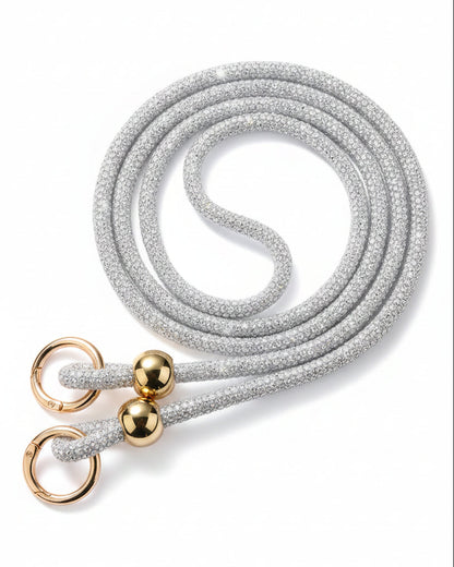 A clear mobile phone case with a luxury rhinestone lanyard attached to it, featuring a sparkling strap and rhinestone clasps.