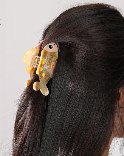 Honey Glitter Fish claw clip worn in a half-up hairstyle